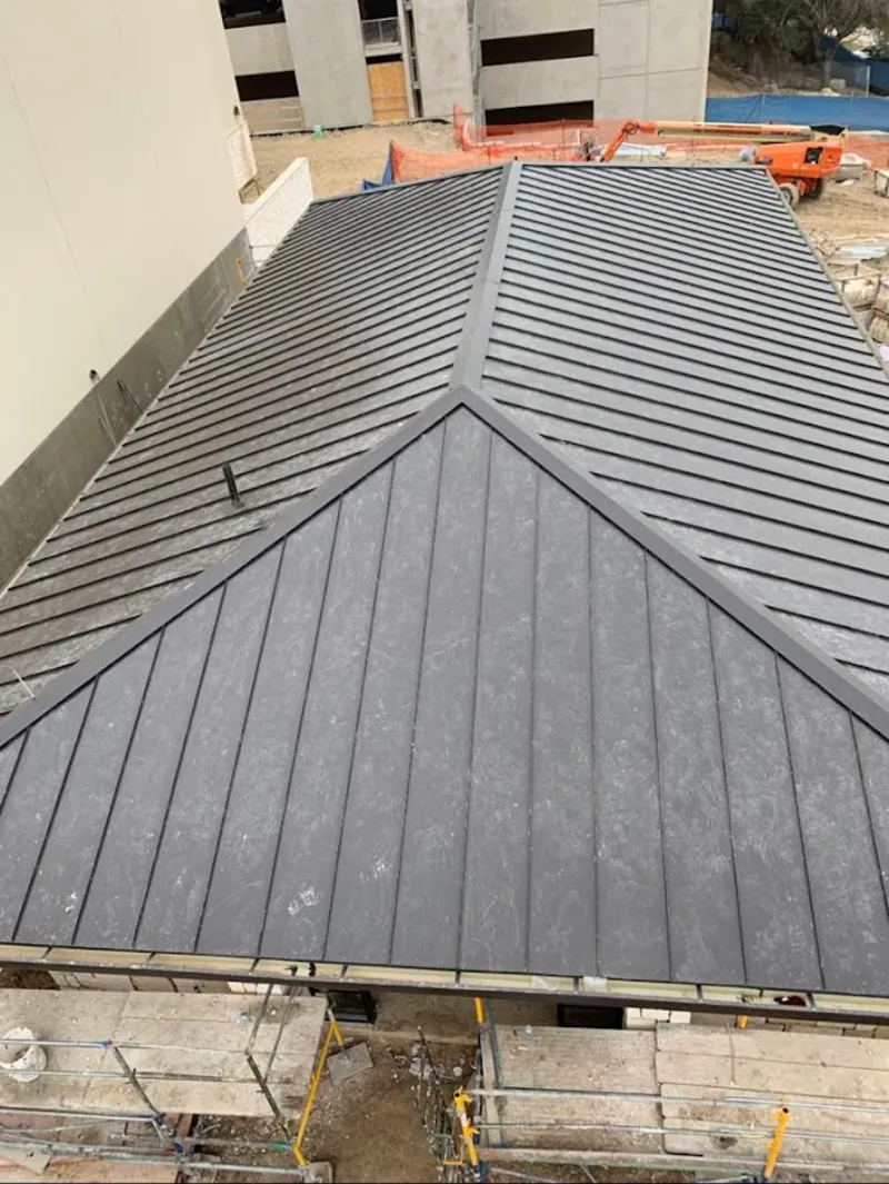 Commercial metal roof construction with crane equipment in East Earl