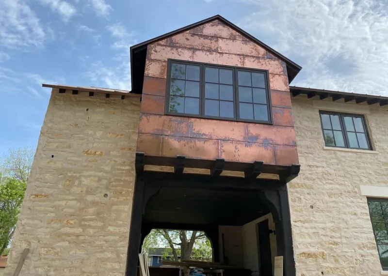 Copper metal panel facade on a stone building for Skylight Installation in East Earl